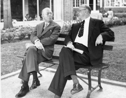 Karl Darrow (left) sitting on bench outdoors talking with Henry Barton (right) at American Physical Society (APS) Meeting.